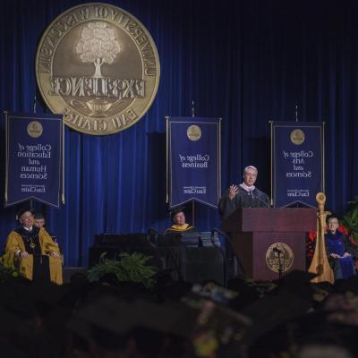 male alumni awardee giving the "Charge to the Class" address in ceremony